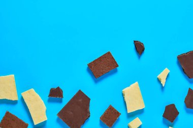 Çeşitli gözenekli çikolataların parçaları mutfaktaki mavi masanın üzerinde yatıyor. Mesaj için yer var. Üst görünüm