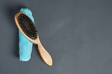 Temizlik için ahşap saplı ya da yuvarlanmış mavi havlunun yanındaki ayakkabılı bir ters fırça banyodaki koyu beton masada yatıyor. Üst Manzara. Metin için boşluk