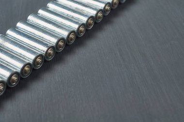 Kirli bataryalarla dolu bir sıra. Ya da koyu beton masadaki aaa büyüklüğünde. Geri dönüşüm konsepti. Çevreyi koru. Alternatif enerji