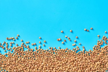 Mutfaktaki mavi masanın üzerine saçılmış karabuğday taneleri. Tarım kavramı