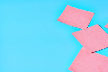 Mavi arka planda bir sürü pembe kare boş kağıt çıkartması vardı. Boşluğu kopyala