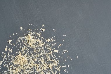 Marangozluk atölyesinde koyu beton yüzeyine saçılmış ahşap talaş.