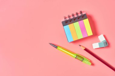 Pembe tezgahta kırtasiye aksesuarları olan bir işyeri. İş ya da okul konseptine dönmek. Sekreterlerin çalışma alanı. Üst Manzara. Düz yatıyordu. Boşluğu kopyala