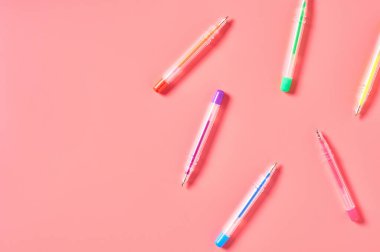 Pembe tezgahta renkli kalemleri olan bir işyeri. İş ya da okul konseptine dönmek. Sekreterlerin çalışma alanı. Üst Manzara. Düz yatıyordu. Boşluğu kopyala