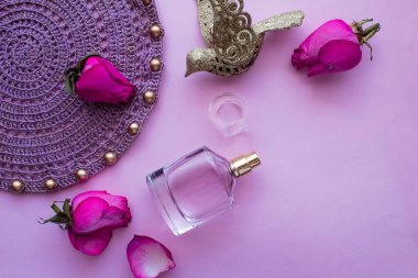 Parfüm tomurcukları ve pembe arka planda gül yaprakları, boncuklu örgü peçete, güzellik konsepti, pembe parfüm kokusu
