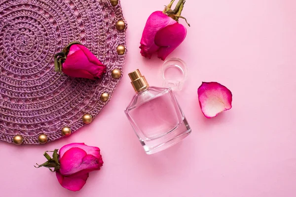 Perfume rosa brotes y pétalos de rosa sobre un fondo rosa, servilleta de punto con cuentas, concepto de belleza, perfume rosa fragancia — Foto de Stock