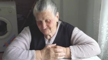 Yüzünde sivilceler olan yaşlı büyükanne masaya oturur ve hikayeyi anlatır.