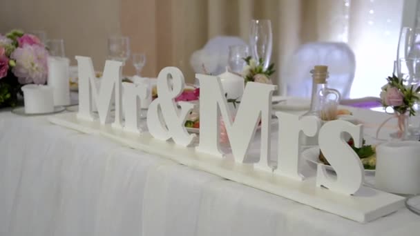 Mr Mrs Huwelijksbord op bruid en bruidegom tafel. bruiloft tafel versierde bloemen — Stockvideo