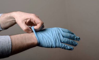 adam bir çift lateks eldiven üzerinde koyarak