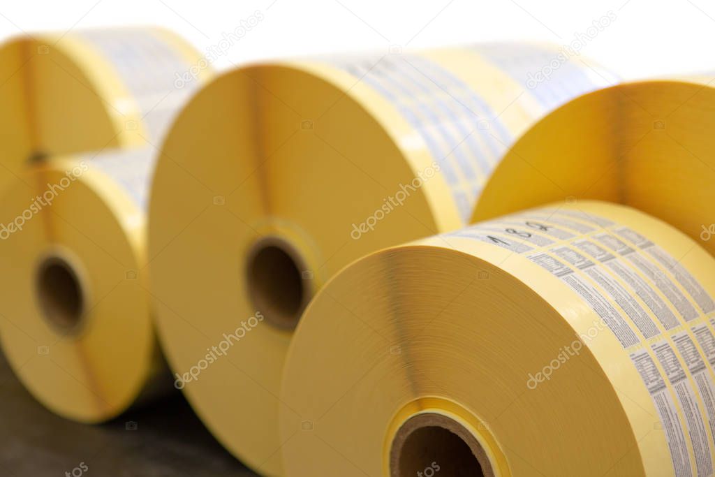 Reels of printed adhesive labels before slitting or cutting isolated on white background. Bunch of printed rolls.