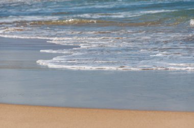 Kum ve dalgalı güzel sahil arka planı