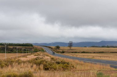 Long countryside road with two lane asphalt road and a car 