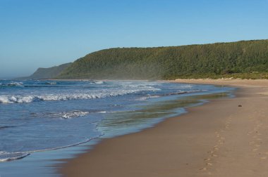Empty sand beach landscape with waves and sand with footprints