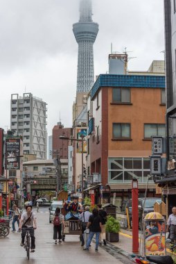 People on streets of Taito district in Tokyo with Skytree on the