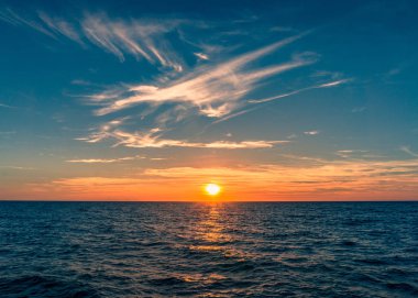 Spectacular sunset with colorful sky and sun going down horizon