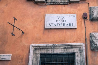 Street sign on old building in Rome. Tourist navigation