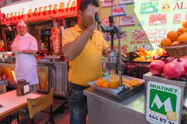 Man squeezing oranges into orange juice using press machine