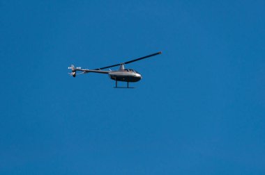 Helicopter flying against clear blue sky on the background