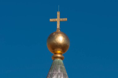 Golden cross with blue sky on the background