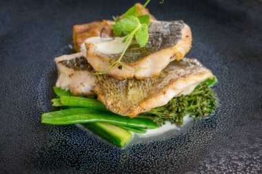 Brokoli çiçekli ızgara balık filetosu ve yeşil bezelye. 