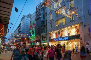 Crowd of people on Istiklal street at night with advertisement o