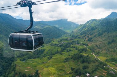 Cable car cabin riding over picturesque green rice terraces in S