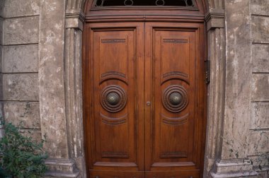 Old decorated wooden closed door with round metallic door handle