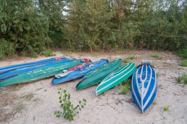 Green and blue kayaks, canoe boats drying on sand