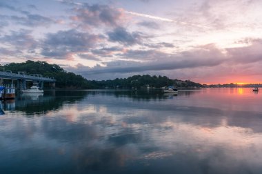 Yatları ve deniz manzaralı evleri olan nehirde güzel bir gün doğumu.