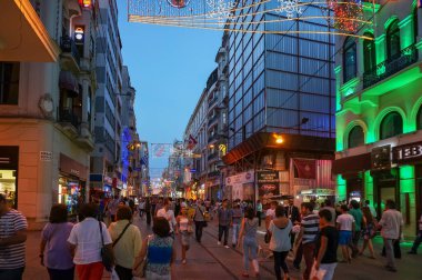 Crowd of people on Istiklal street at night with advertisement o