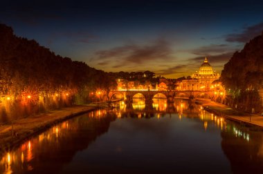 Rome cityscape at night with illuminated arch bridge and St Peters Basilica