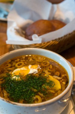 Ekşi krema ve dereotlu bir kasede borş çorbası.