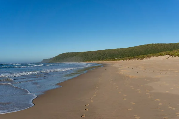 Leeg zandstrand landschap met golven en zand met voetafdrukken — Stockfoto