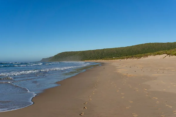 Empty sand beach landscape with waves and sand with footprints — Stok fotoğraf