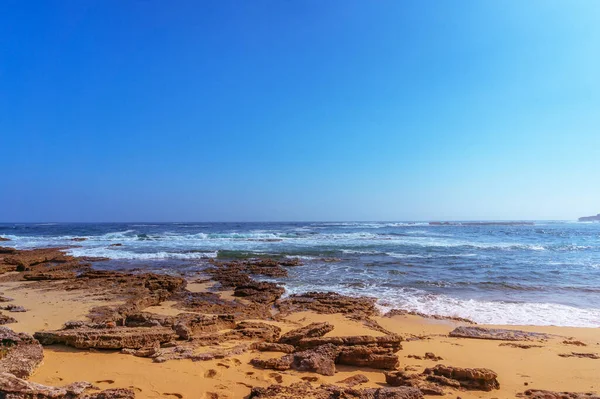 Seascape com costa arenosa com rochas no dia ensolarado — Fotografia de Stock