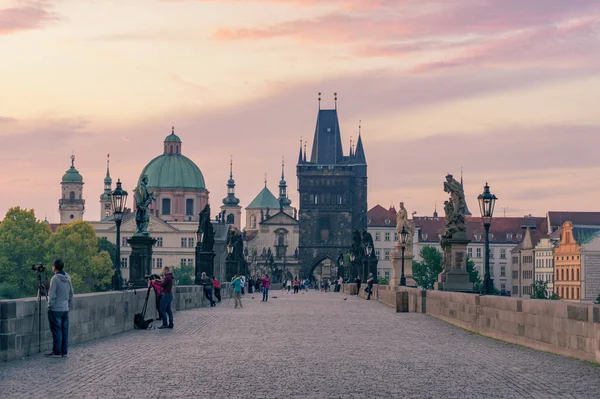 Карлов мост в Праге на рассвете с фотографами и туристами — стоковое фото