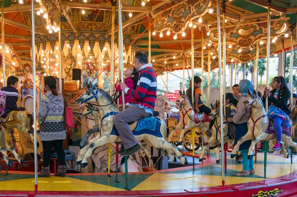 Merry-go-round carrossel com crianças e adultos se divertindo — Fotografia de Stock