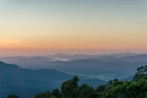 Beautiful nature landscape with mountains in a fog on sunrise — Stock Photo, Image