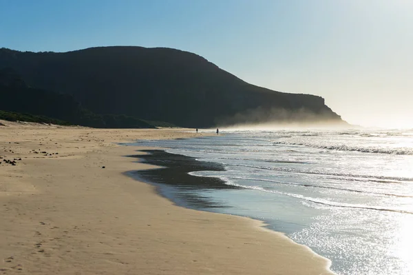 Hermoso paisaje de playa soleado con olas suaves y niebla de agua — Foto de Stock