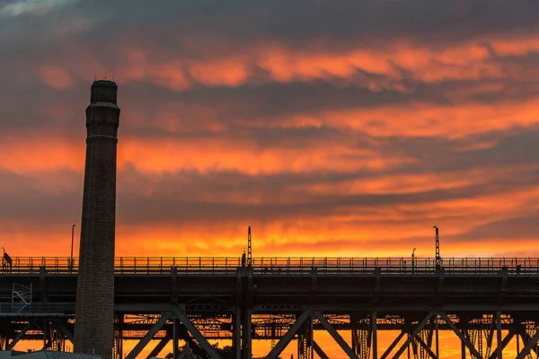 Industrial architecture silhouettes against vivid sky on the bac