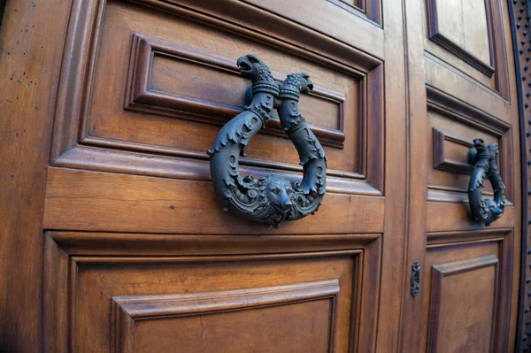 Old black metal, cast-iron door handle on wooden door — ストック写真