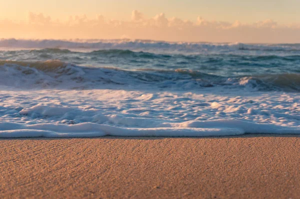Close up de praia de areia com espuma branca de ondas oceânicas — Fotografia de Stock