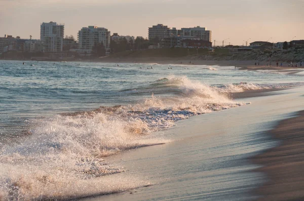 Ola del océano aplastándose en la playa al atardecer — Foto de Stock