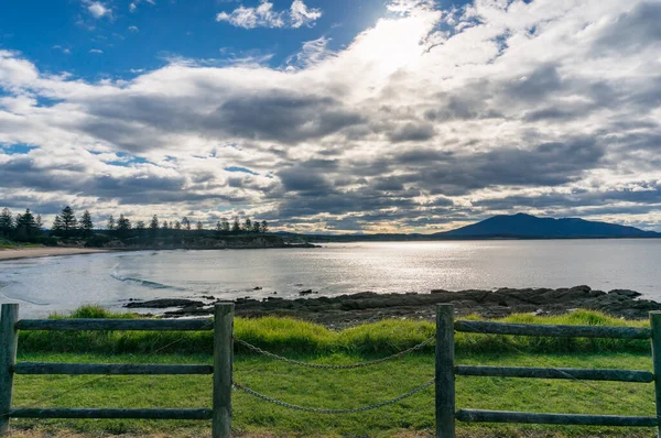 Waterfront landscape with wooden fence and chains, mountains on — 스톡 사진