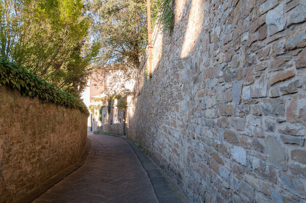 Narrow European street with stone wall in Florence city of Italy