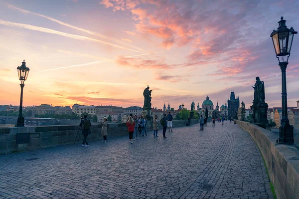 Turisták napkeltekor a Károly híd mérföldkő Prágában — Stock Fotó