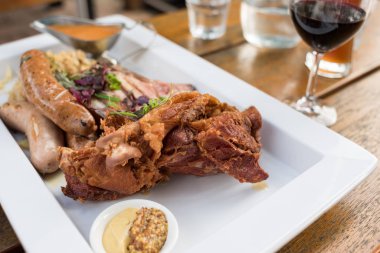 Kızarmış et, sosis, hardal tohumu soslu et tabağı.