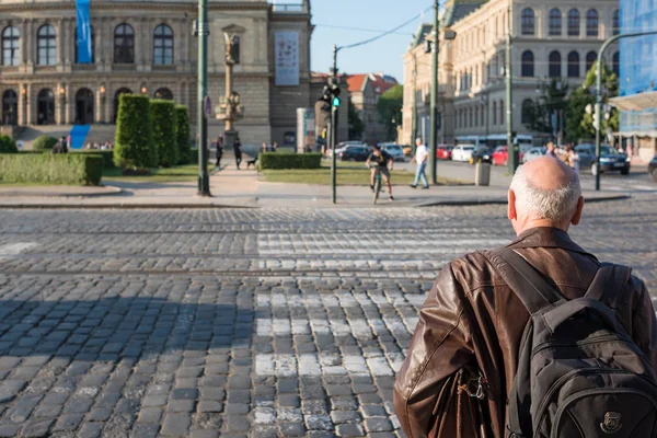 Senior man met rugzak wandelen door de straten van Praag stad. Opnieuw — Stockfoto