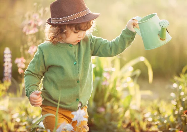 La niña con la regadera en el jardín — Foto de Stock