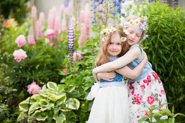 Deux petites sœurs s'embrassent dans le jardin — Photo